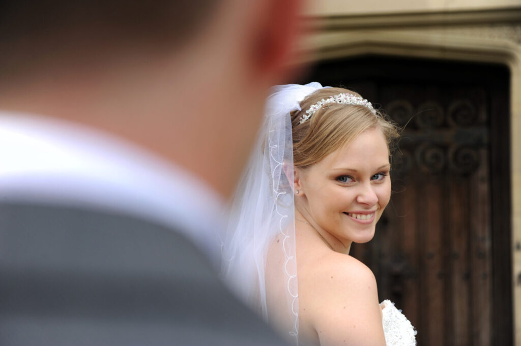 bride smiles at groom over her shoulder, fanhams