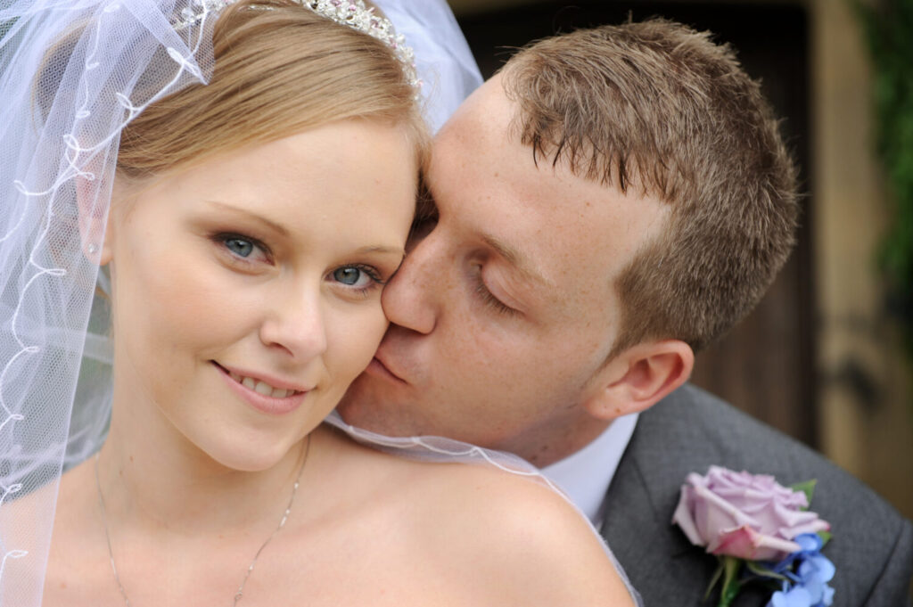 groom kisses bride, cheek, tender