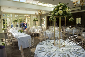 wedding breakfast, st michaels manor, white tablecloths, high table floral arrnagements, people mingle background