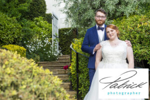 bride red hair pinned up, ginger, bride, wedding dress white, groom navy blue, bow tie, steps, bushes, exit, gardens, white wall, mansion