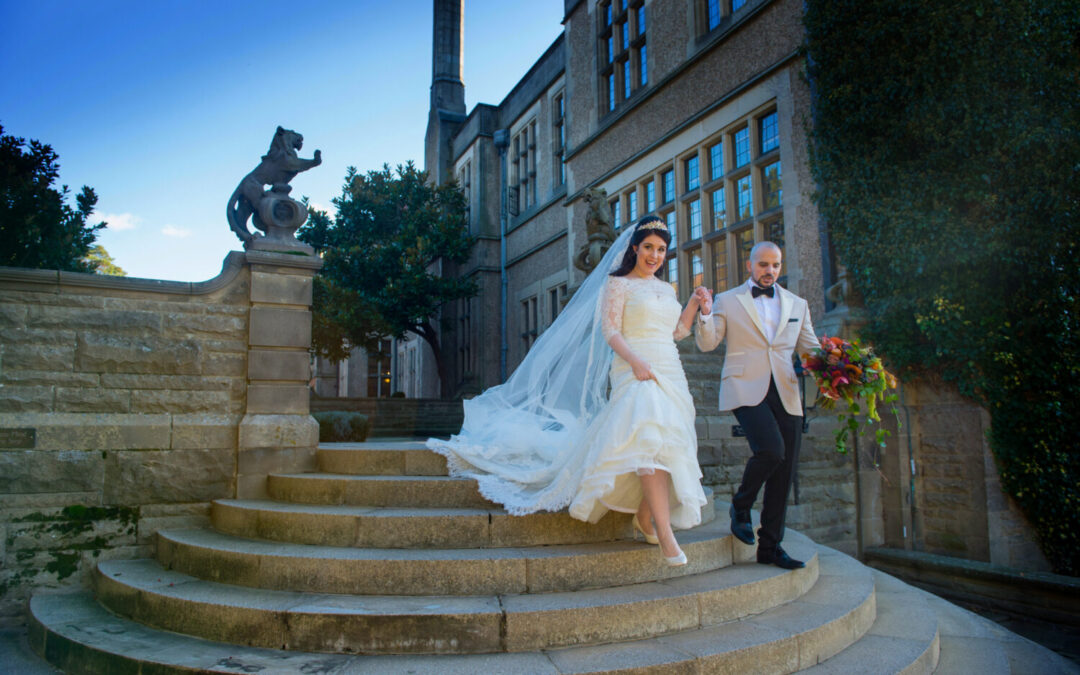 Dee and Giggs, real life wedding, walking down the steps of fanhams hall. the groom carries the bouqet and holds his wife’s hand