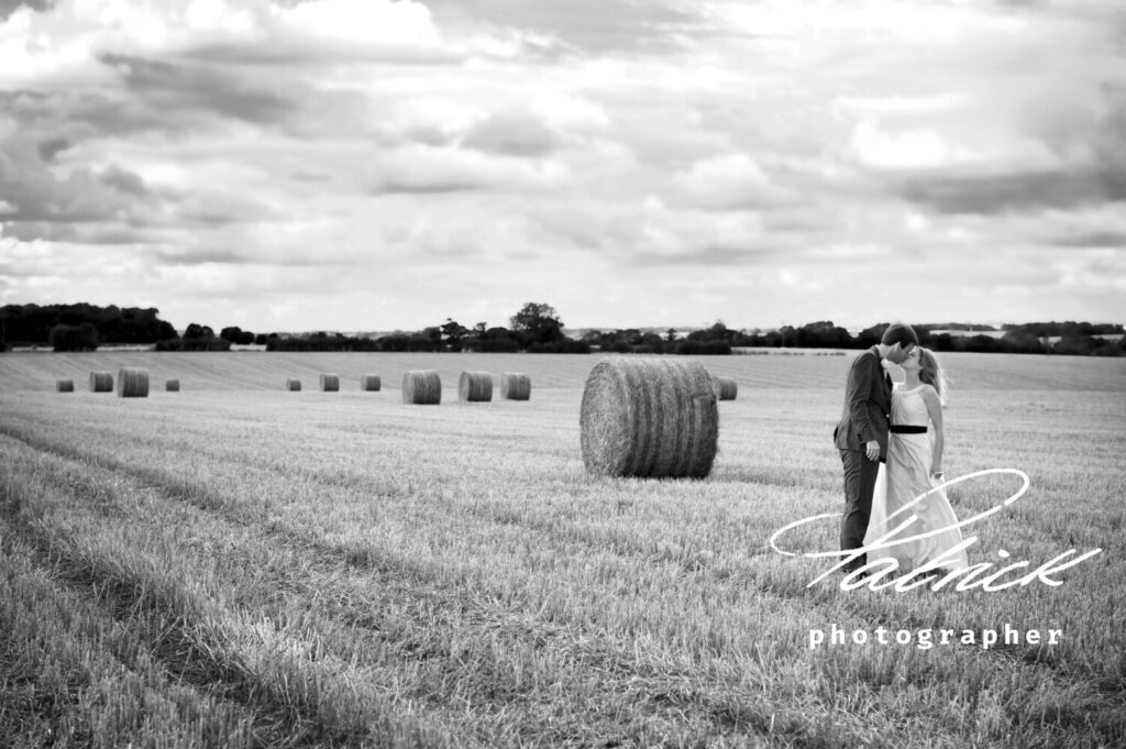 millingbarn, bluntswood hall, bride and groom, black and white, field, long grass, hay bales,atmospheric shot, button hole