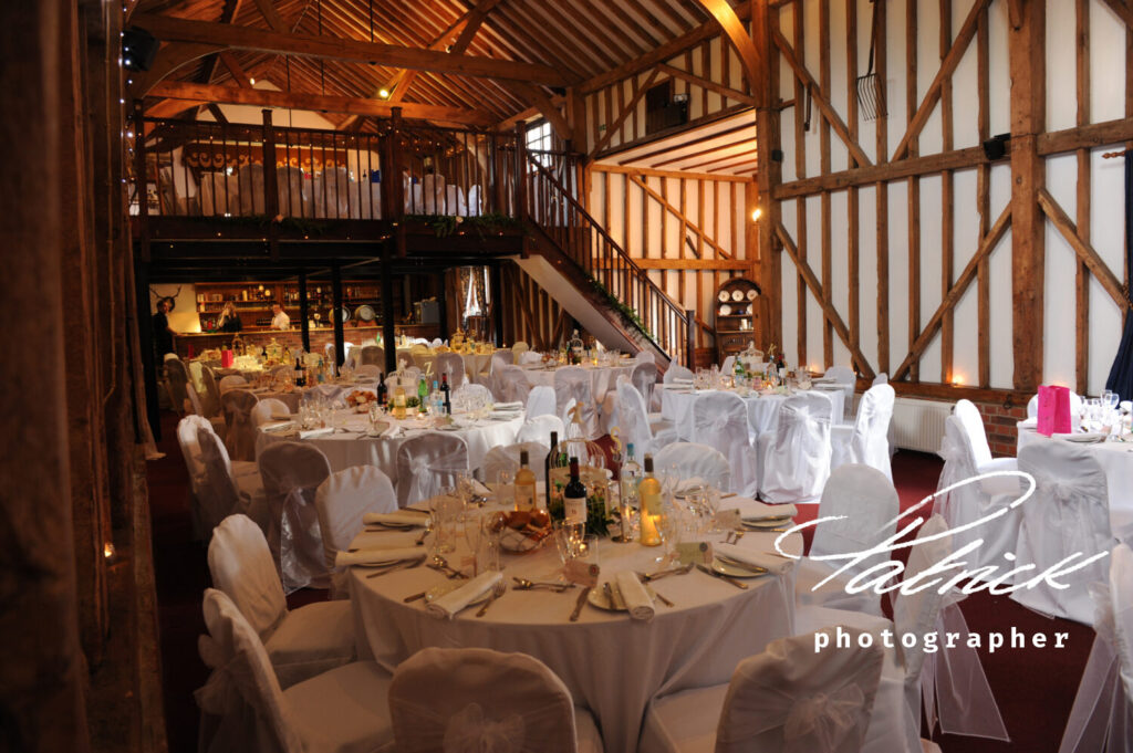 interior at millingbarn, formerly Bluntswood Hall. Room decorated for wedding breakfast. barn style white walls and wooden beams, red carpet.