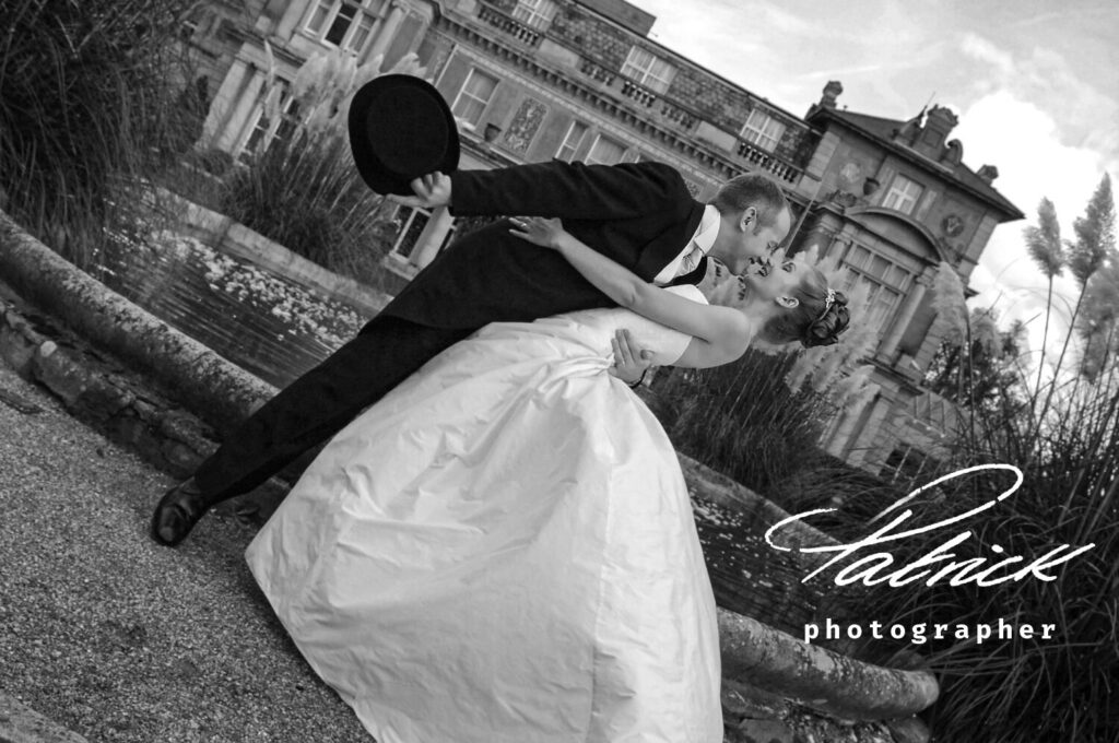 https://www.downhall.co.uk down hall country house hotel, bride leans back and groom leans towards her. black and white image. angle