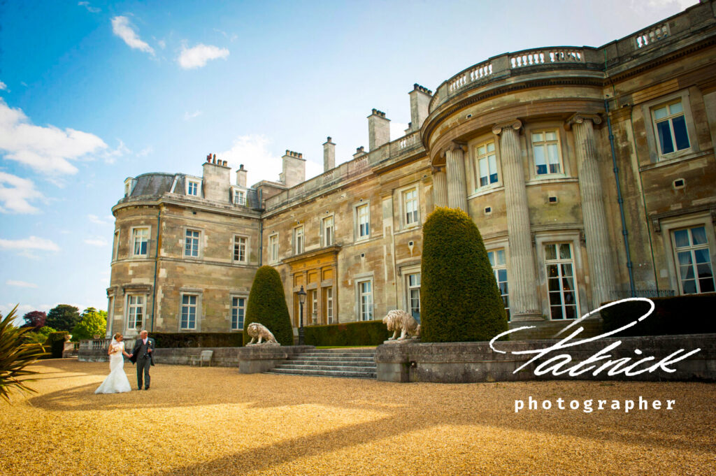 18th century Mansion House set at Luton Hoo. bride and groom walk hand in hand wedding day