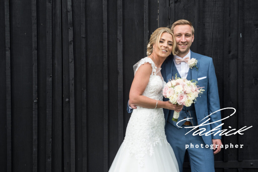 bride and groom in front of barn doors