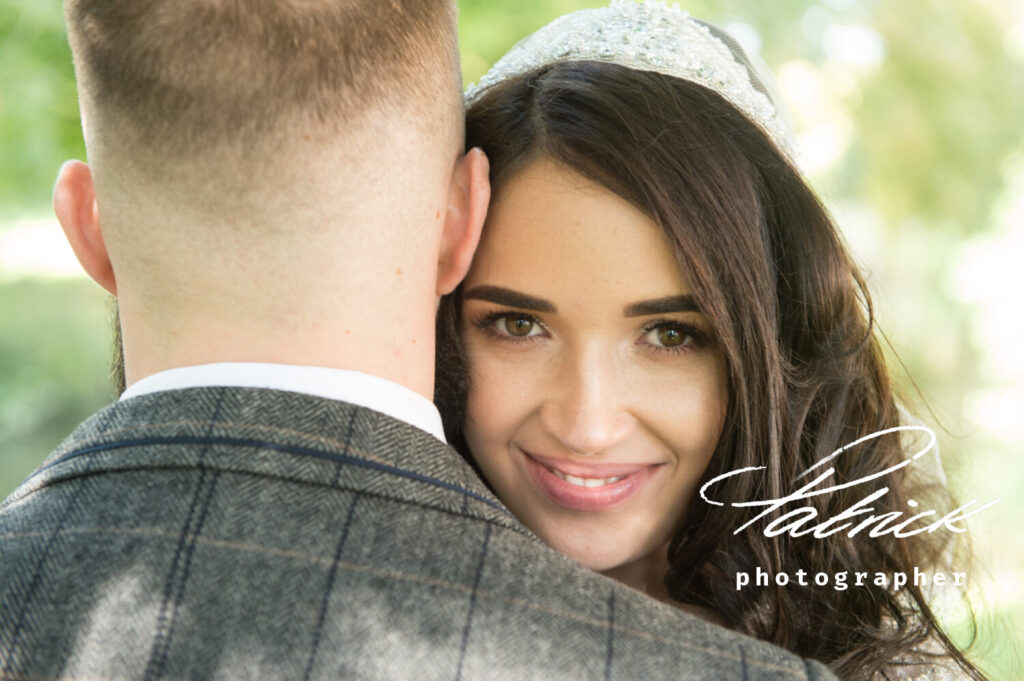 brunette bride looking over groom shoulder. grey checked jacket