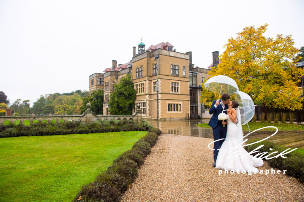 fanhams hall background, Pavillon, rainy wedding day, exterior, trees, mansion house, gardens, bride and groom, umbrellas, kissing