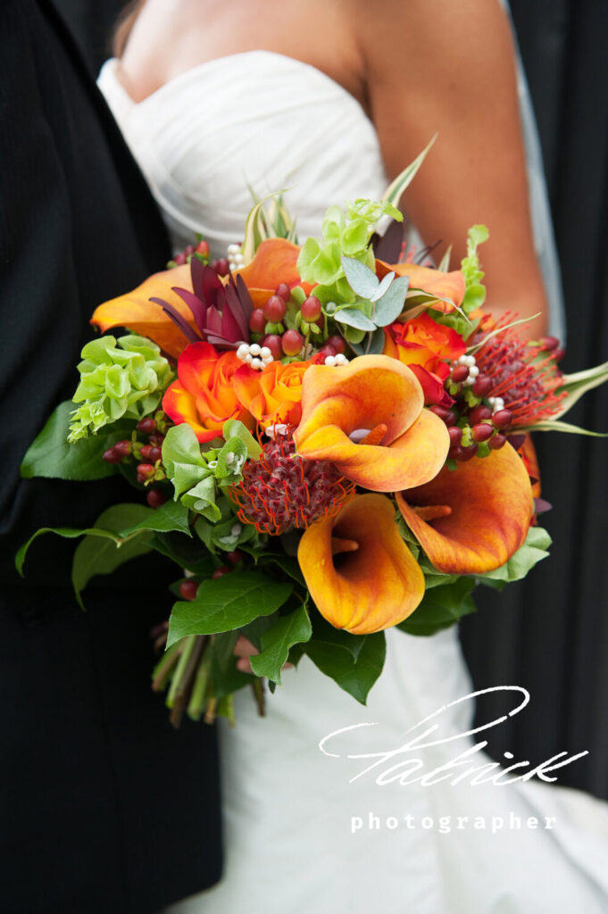 seasonal orange lillies bouquet, bride and groom background