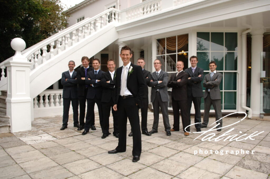 groom and groomsmen pose white steps