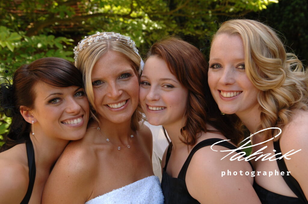 bride wears white, glass bead tiara and necklace, bridesmaids wear black dresses