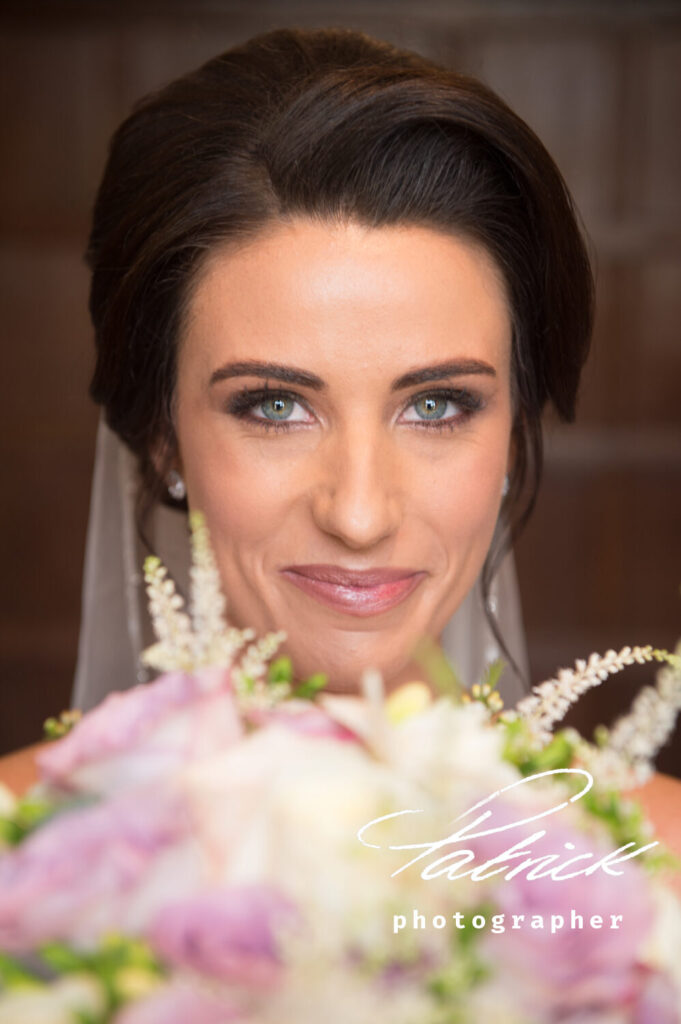 Amy and wedding bouquet, blue eyes, dark hair, looking into camera