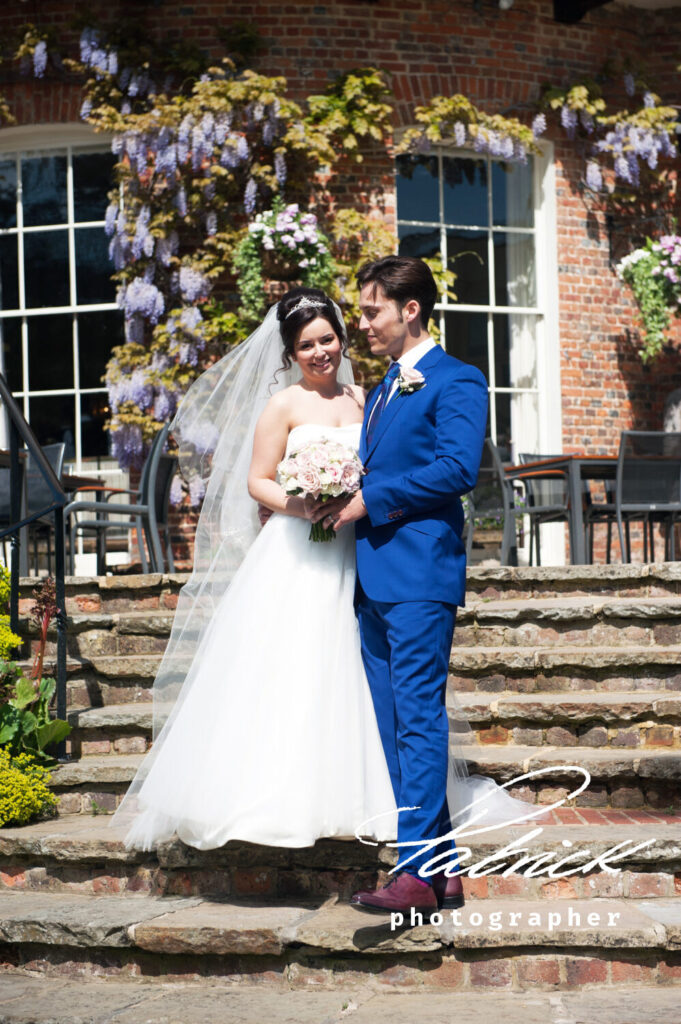 st Michaels manor bride and groom pose on the steps exterior conservatory adorned flowers