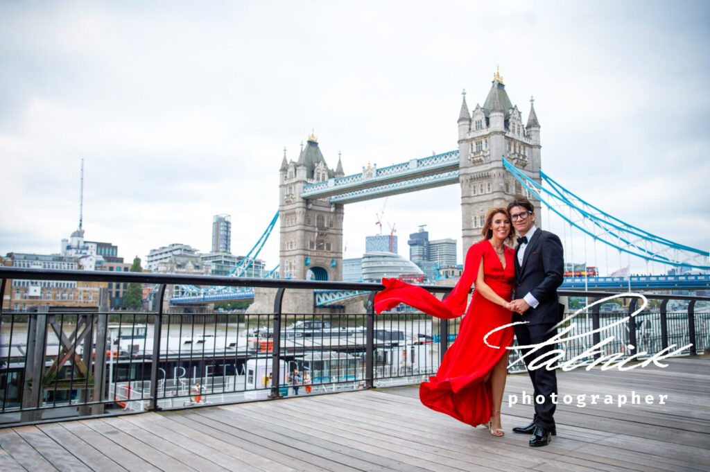 bride (wearing red floaty dress) and groom at tower bridge London