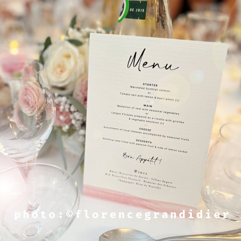 menu wedding stationery, flowers and glasses in background