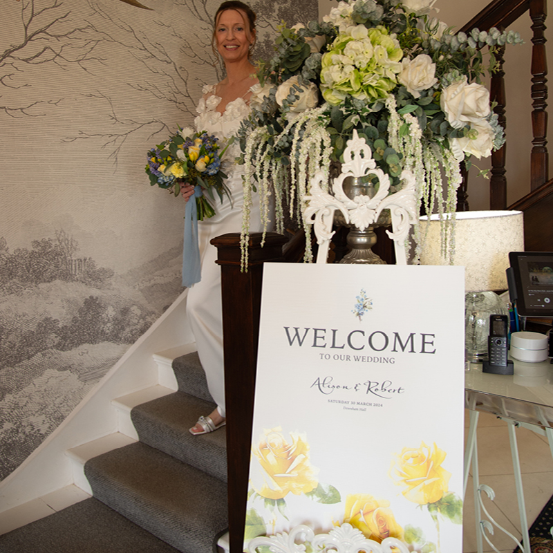 alison bride descending stairs behind welcome stationery board design