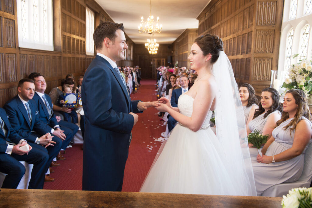 bride and groom at altar, exchanging vows, wedding congregation, wedding ceremony, red carpet, exchange rings