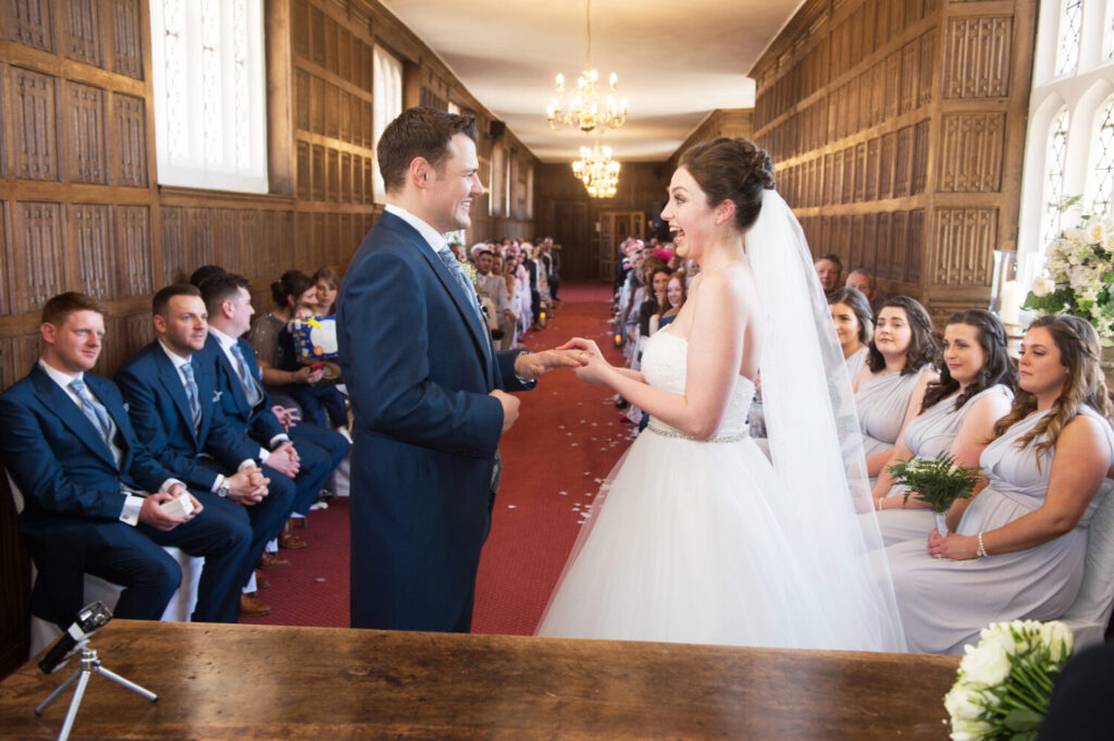 bride and groom at altar, exchanging vows, wedding congregation, wedding ceremony, red carpet, exchange rings