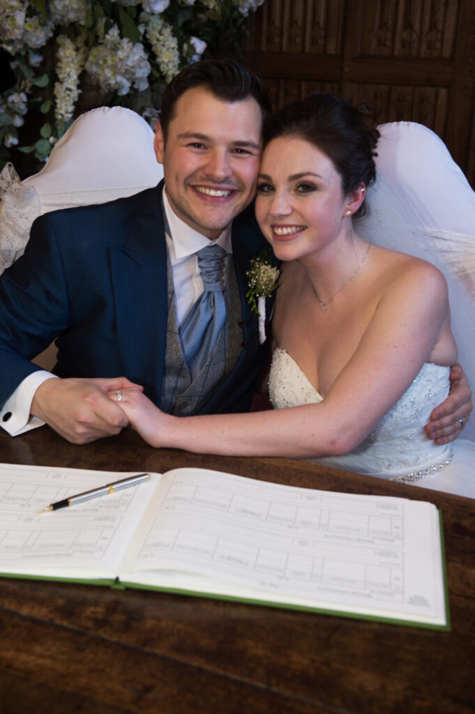 bride and groom sign the register