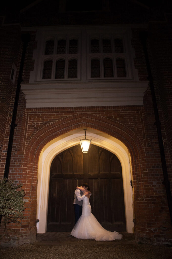 bride and groom at night in front of the main entrance at night