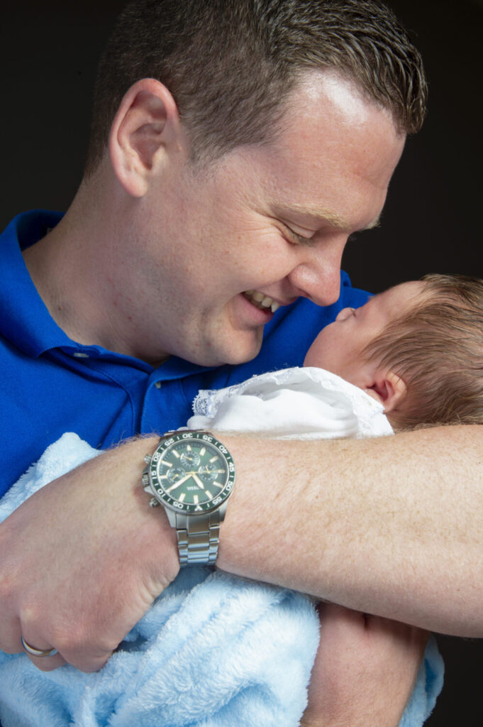 new dad, newborn baby boy, cuddles, smiles, natural, studio, portrait